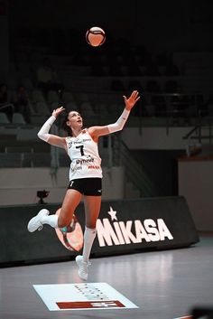 a woman jumping in the air to hit a volleyball