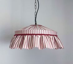 a red and white striped light hanging from a chain