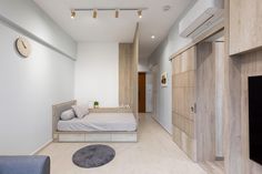 a bedroom with white walls and wood flooring next to a blue couch in front of a fireplace