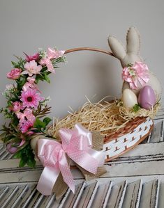 a basket filled with pink flowers and an easter bunny