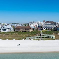 houses on the beach with white sand and clear blue sky