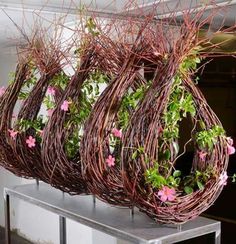 some pink flowers are hanging from a wire planter