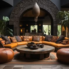 a living room filled with lots of couches and tables in front of an archway