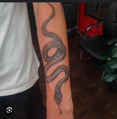 a man's arm with a snake tattoo on it