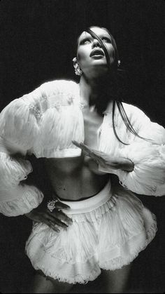 black and white photograph of a woman with her hands on her hips wearing a ruffled skirt