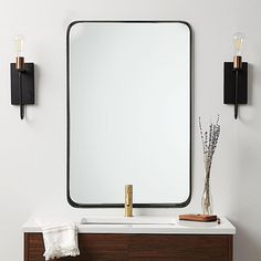 a bathroom vanity with a large mirror and two lights on the wall next to it