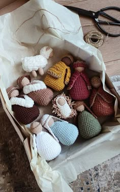 there are many crocheted nativity items in the box on the floor next to some scissors