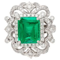 18k white gold Art Deco inspired cocktail ring mounts this vibrant GIA certified 3.75 carat Colombian Emerald center stone and 156 round cut diamonds of 1.35 carats total. The Emerald bears excellent luster and crystal, with a clean face that radiates deep green color hue. Flanked by a round cut diamond halo. _________________________________ Center Stone Details: Natural Beryl; Emerald - Carat: 3.75 - Color: Green - Cut: Emerald - Treatment: Moderate (F2) - Certificate: GIA - Certificate No # : 2155655071 - Dimensions: 10.84 x 9.08 x 4.90 mm _________________________________ Ring Details: - Metal: 18 karat white gold - Diamonds: 156 round cut diamonds, 1.35 ctw (F-G color, VS1-VS2) - Total Weight: 11.64 grams - Size: 7 U.S. (adjustable) _________________________________ SHIPPING TIMES: US Wide Band Engagement Ring, Jewellery Board, Natural Emerald Rings, Green Emerald Ring, Antique Clocks, Unusual Jewelry, Colombian Emeralds, Gold Art Deco, Gold Band Ring