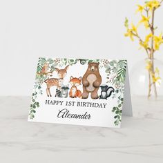 a happy 1st birthday card with woodland animals and flowers in front of a white background