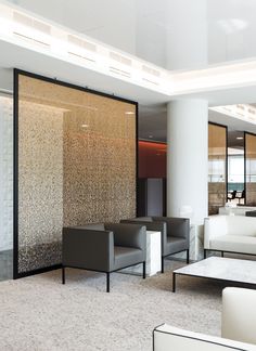 a living room with couches and chairs in front of glass partitions on the wall