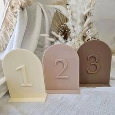 three small wooden numbers sitting on top of a bed