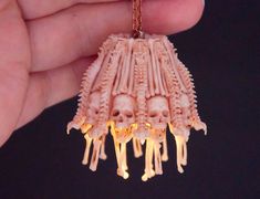 a hand holding a necklace made out of fake human bones and glowing lights in the dark