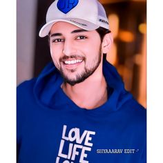 a man wearing a blue hoodie and white hat with the words love life on it