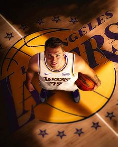 a basketball player holding a ball in his right hand and posing for a photo on the court