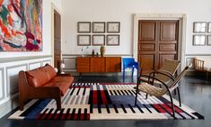 a living room filled with furniture and pictures on the wall above it's doorway