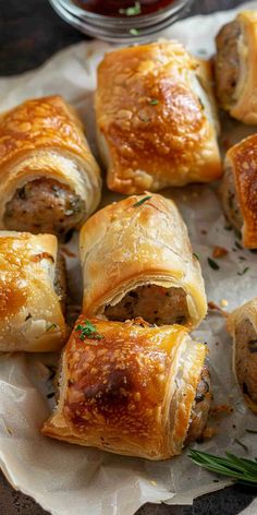 sausage wrapped in puff pastry on top of parchment paper