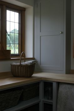 a basket sitting on top of a wooden counter next to a window in a kitchen