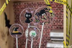 three halloween lollipops with spooky eyes and witches on them are in front of a brick wall