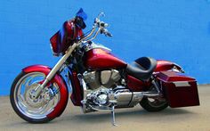 a red motorcycle parked in front of a blue wall