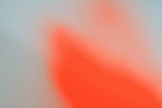 a blurry image of an orange object on a white surface with red and blue colors