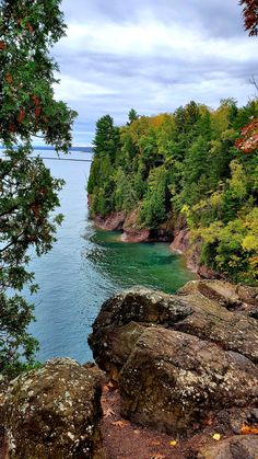 the water is crystal blue and green as it sits next to some large rocks on the shore