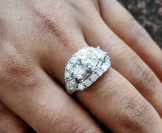 a close up of a person's hand with a diamond ring on their finger