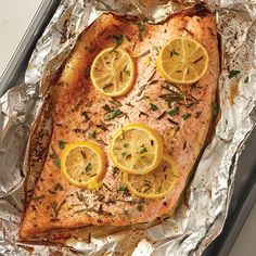 salmon with lemons and herbs on aluminum foil