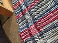 a blue and red rug sitting on top of a floor next to a wooden table