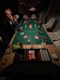 a man sitting at a casino table drinking from a beer glass while playing roulejack