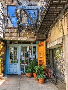 an alleyway with potted plants and a bicycle parked in front of the door