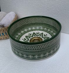 a green and white bowl sitting on top of a counter