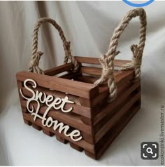 a wooden crate with rope handles and the words sweet home on it