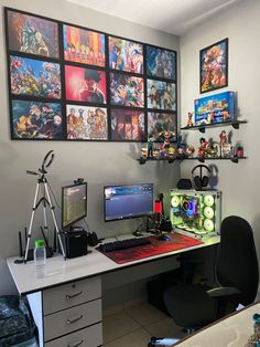 a computer desk topped with two monitors and a desktop pc next to a wall full of pictures