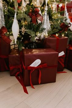 presents under the christmas tree are wrapped in red ribbon