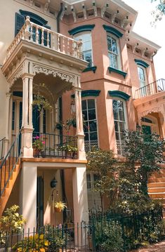 a large pink house with many windows and balconies