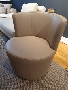 a tan leather chair sitting on top of a rug