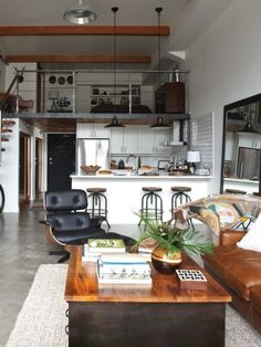 a living room filled with furniture next to a kitchen