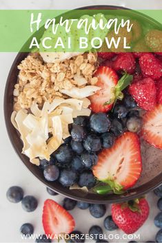 a bowl filled with granola, blueberries and strawberries on top of it