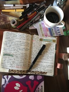 an open book sitting on top of a table next to a cup of coffee