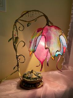 a lamp that is on top of a table next to a rock and tree branch