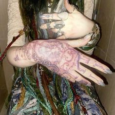 a woman with tattoos on her arm and hand