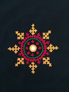 a candle is lit in the center of an embroidered snowflake