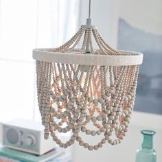 a white chandelier with beads hanging from it's ceiling in a living room