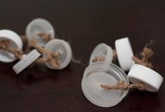 three small white buttons tied together on a table with twine and rope around them