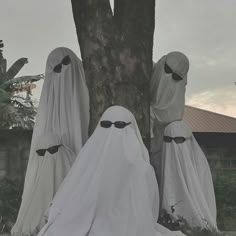 three ghostly people standing next to a tree