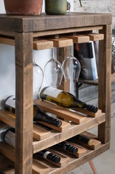 a wooden wine rack with bottles and glasses