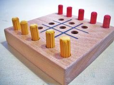 a wooden board game with red and yellow pins