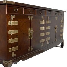 a large wooden cabinet with brass hardware on it's doors and drawer compartments,