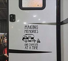 a camper is parked on the side of a train with its door open and it's saying making memories one campsite at a time