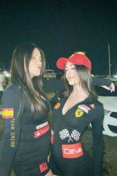 two women dressed in racing outfits standing next to each other